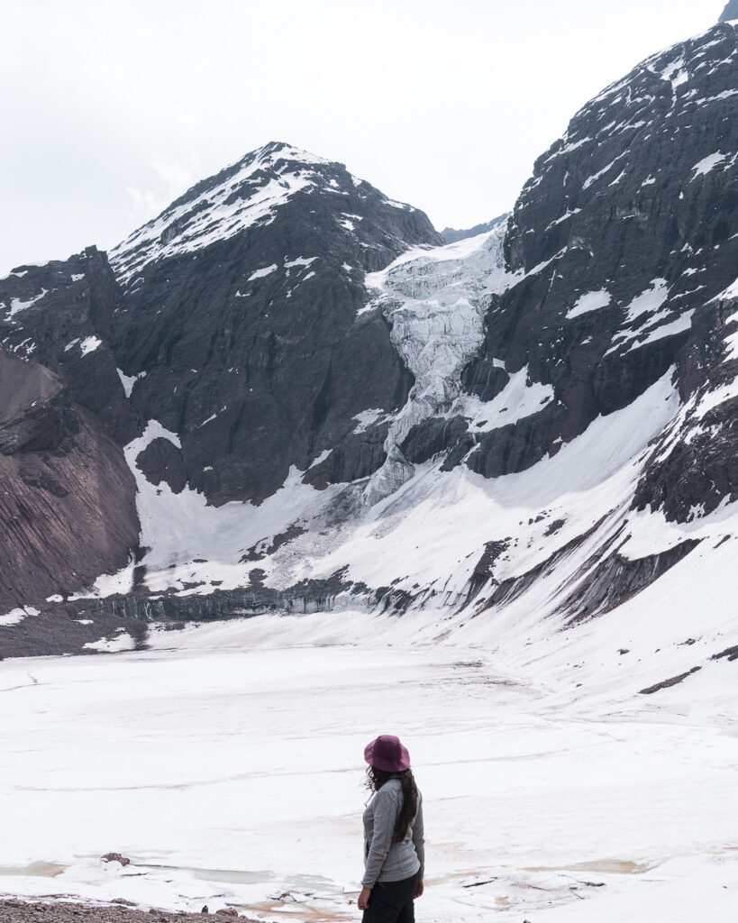 mujer mirando glaciar colgante en la montaña